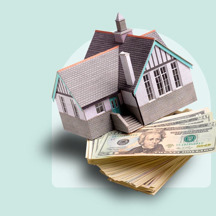 photo illustration of house balanced on stack of cash, light blue background